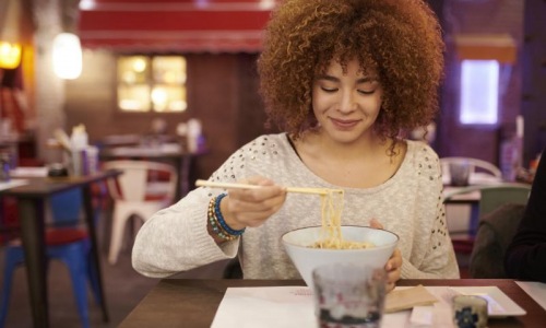 a person eating noodles
