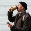 Man walking down the road drinking coffee
